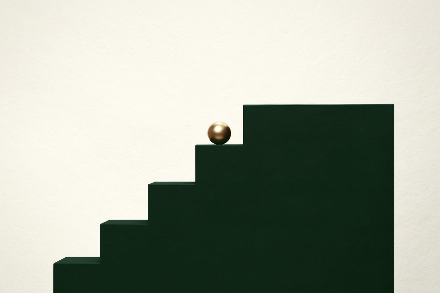 A staircase of green blocks with a gold sphere on the top step